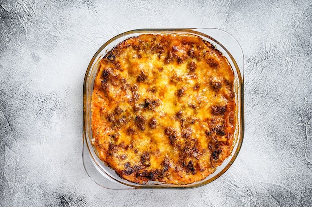 Lasaña clásica con salsa boloñesa en una fuente para horno. Fondo blanco. Vista superior.