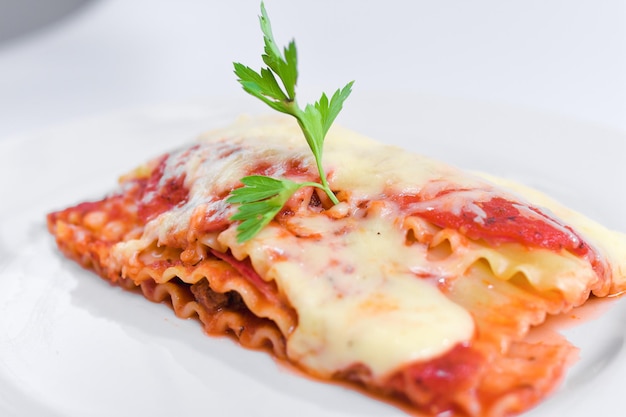 lasaña italiana con queso y salsa de tomate adornada con perejil