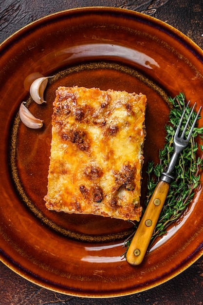 Lasaña italiana con salsa boloñesa de tomate y carne picada de ternera en un plato rústico