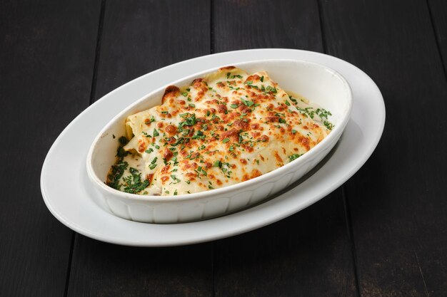 Lasaña con queso, pollo y verduras en un plato