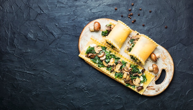 Lasanha com cogumelos, champignon, queijo e espinafre. Comida tradicional italiana. Copie o espaço