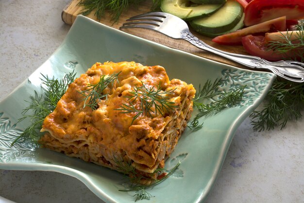 Lasanha de carne caseira com legumes frescos e queijo parmesão em prato de comida italiana