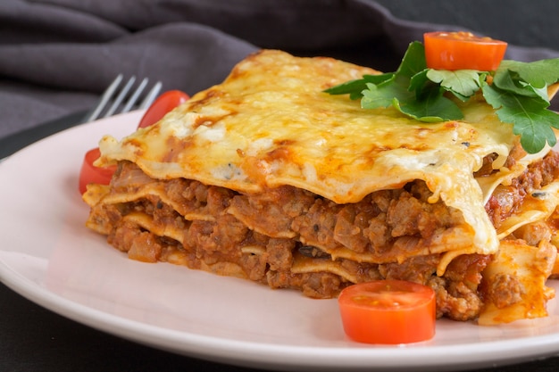 Lasanha de carne em uma mesa de madeira.