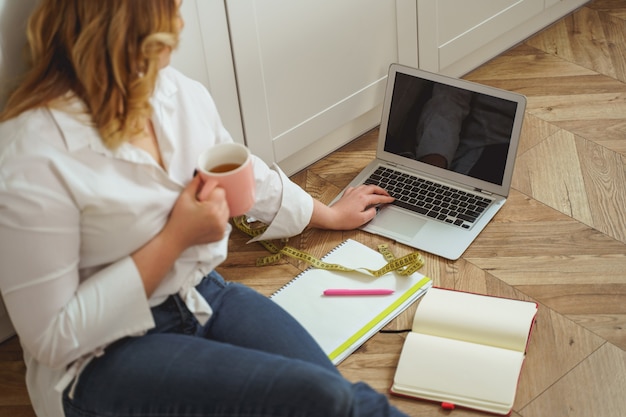 Lass mich das überprüfen. Hübsche Frau, die auf ihren Computer schaut und Pläne für die Einhaltung der Diät macht