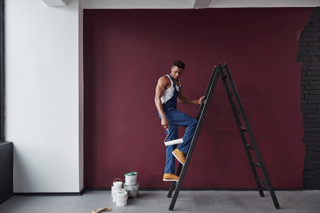 Lass uns das machen. Junge afroamerikanische Arbeiter in der blauen Uniform haben einen Job zu erledigen