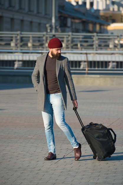Lassen Sie die Reise beginnen Reisende mit Koffer kommen zum Flughafen Bahnhof Hipster bereit Reise genießen Reisetasche tragen Geschäftsreise Man bärtige Hipster-Reise mit großer Gepäcktasche auf Rädern