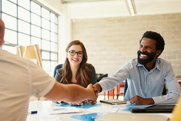 Lassen Sie die Verbindung mit Kreativität und Geschäft beginnen Aufnahme von kreativen Mitarbeitern, die sich in einem modernen Büro die Hände schütteln