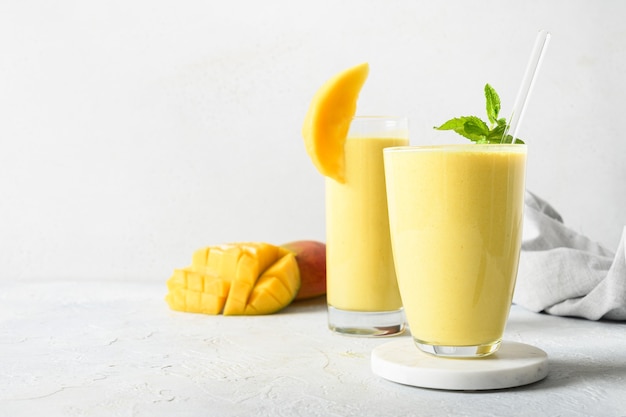 Lassi indio de mango o cúrcuma sobre fondo gris