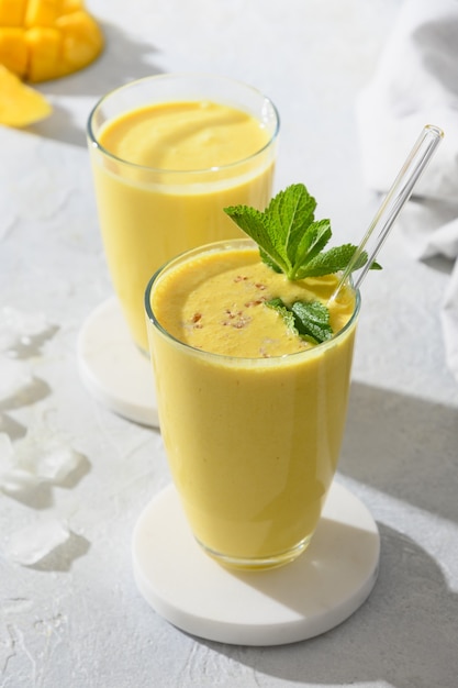 Lassi indio de mango o cúrcuma sobre fondo gris