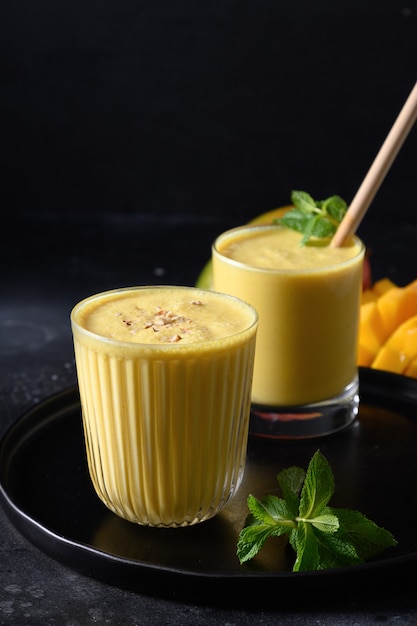 Lassi indio de mango o cúrcuma sobre fondo negro