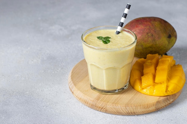 Lassi Mango en vidrio sobre tablero de madera sobre fondo gris Bebida ayurvédica saludable india con mango