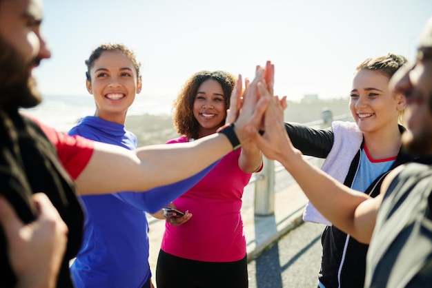 Lasst uns das machen, Jungs Aufnahme einer Gruppe junger, fröhlicher Freunde, die tagsüber vor einer Fitnessübung draußen High Fives geben