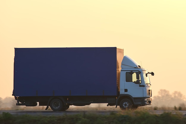 Lastwagen, der abends auf der Autobahn fährt und Güter transportiert Liefertransport- und Logistikkonzept