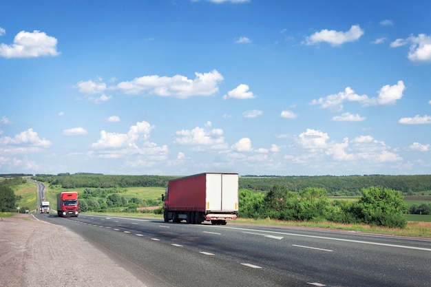 Lastwagen und Autos fahren die Sommerstraße entlang, die Autobahn.