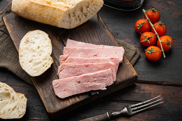 Lata de carne de porco aberta com conjunto de baguete, no fundo da velha mesa de madeira escura