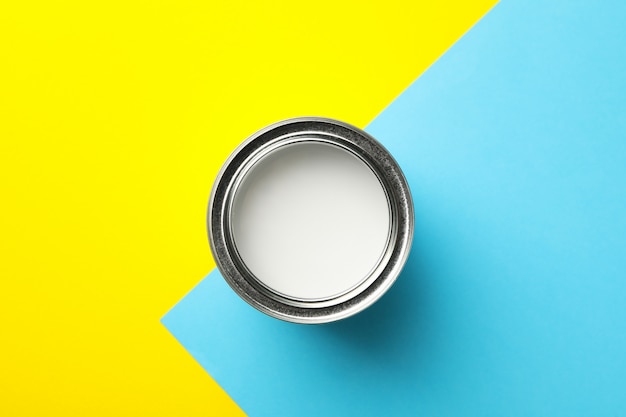 Foto lata de pintura blanca sobre superficie de dos tonos