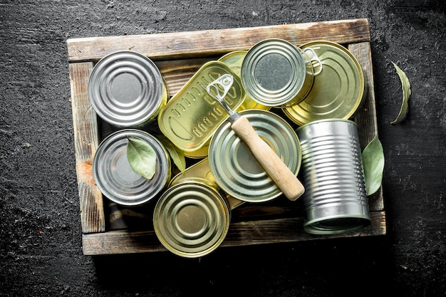 Foto latas cerradas de comida enlatada en una bandeja de madera