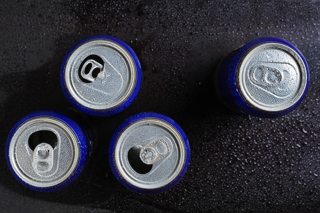 Latas de cerveza en gotas de agua