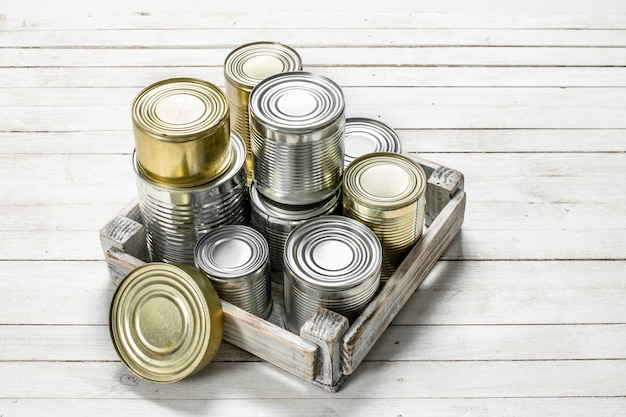 Latas com comida em uma caixa.