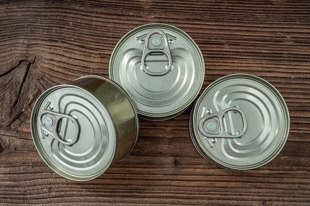 Latas com comida no fundo escuro de madeira rústica