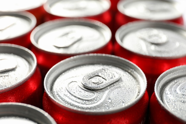 Latas com refrigerante em todo o fundo, close-up.