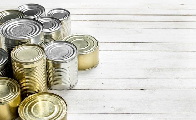 Latas con comida en la mesa de madera blanca