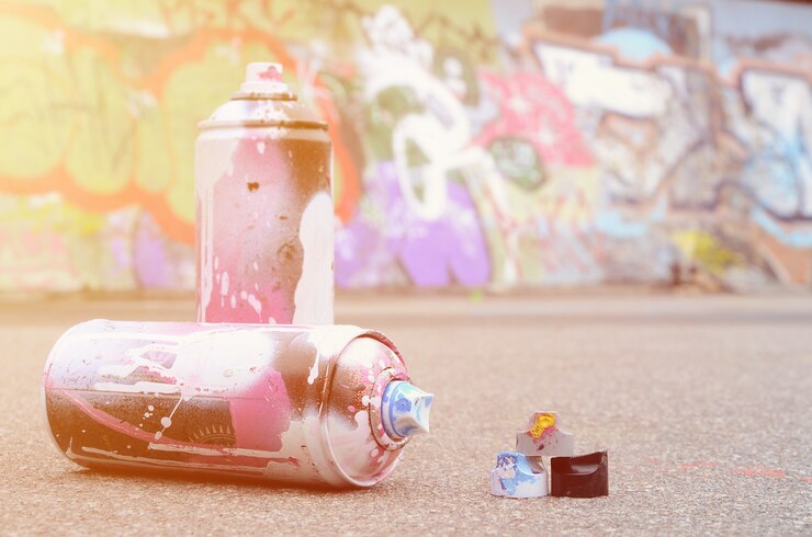 Foto latas de spray usadas com tinta rosa e branca e tampas para tinta spray
