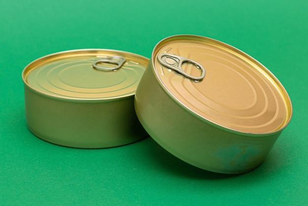 Latas fechadas com bordas em branco sobre fundo verde