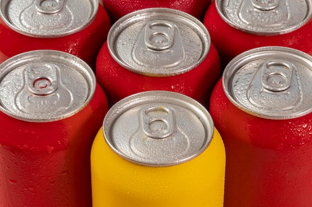 Foto latas de refresco rojo frío con una amarilla para uso conceptual