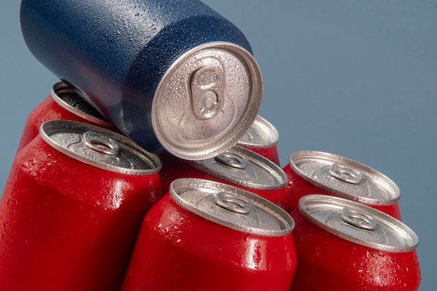 Latas de refresco rojo frío con una azul para uso conceptual