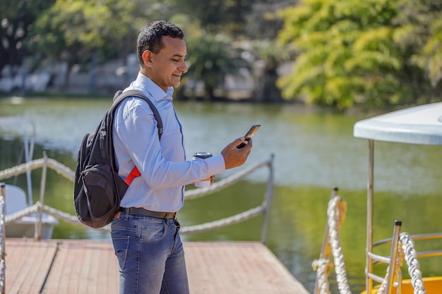 Lateinamerikaner benutzt ein Mobiltelefon auf einem Dock