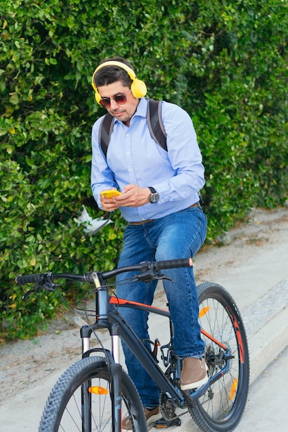 Lateinamerikaner, der beim Fahrradfahren Musik auf seinem Handy hört