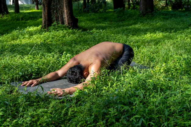 Lateinamerikanischer Mann macht Yoga-Haltung Yoga-Haltung Biene rückwärts Prsthatah Brahmara Wald