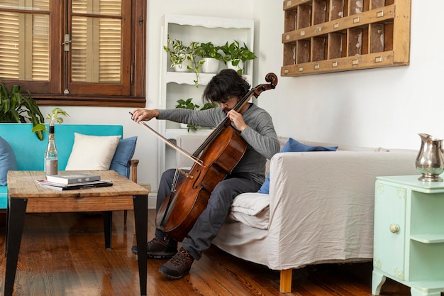 Lateinamerikanischer professioneller männlicher Musiker übt und studiert zu Hause Cello