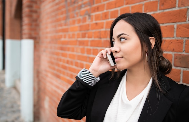 Lateinische Frau, die am Telefon spricht.