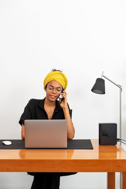 Lateinische Frau, die zu Hause Büro mit Laptop und Dokumenten arbeitet