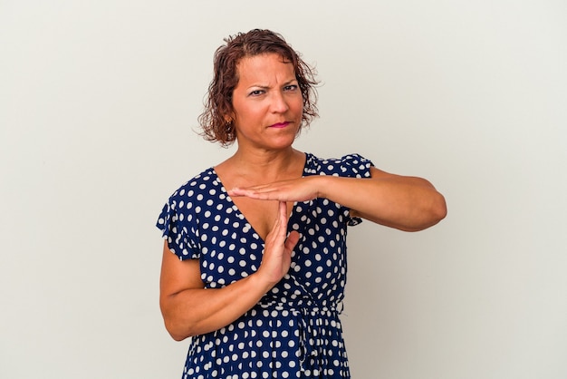Lateinische Frau mittleren Alters isoliert auf weißem Hintergrund, die eine Timeout-Geste zeigt.