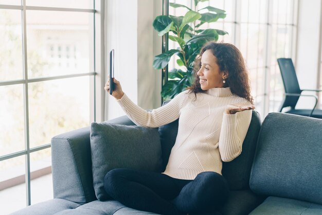 Lateinische Frauenvideokonferenz auf Tablette mit glücklichem Gefühl