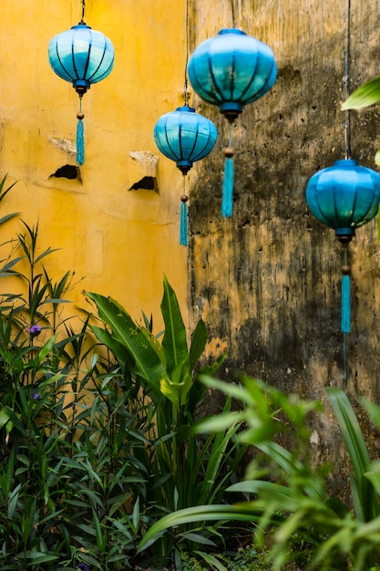 Foto laterna de seda colgada frente a una pared amarilla