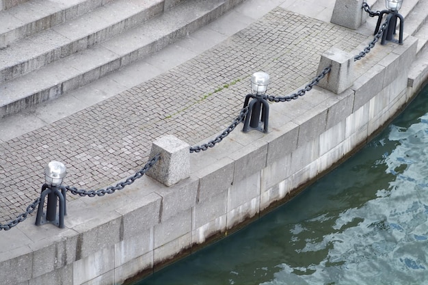 Laternen mit Grenzketten auf der Draufsicht des leeren Flussdammpiers