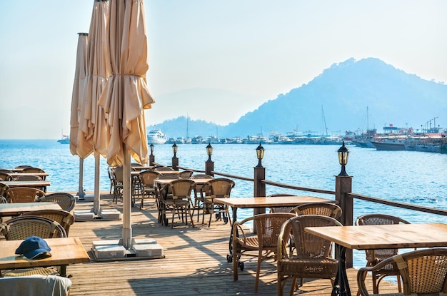 Laternen und Tische auf dem Pier am Meer und Schiffe Marmaris Türkei