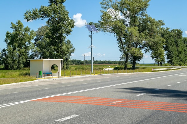 Laternenpfahl mit solarpanel-system auf der straße mit blauem himmel und bäumen autonome straßenbeleuchtung mit sonnenkollektoren straßenlaterne auf batterien von der sonne alternative erneuerbare energiesysteme