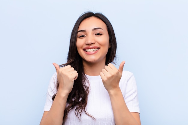 Latina bonita jovem contra a parede plana