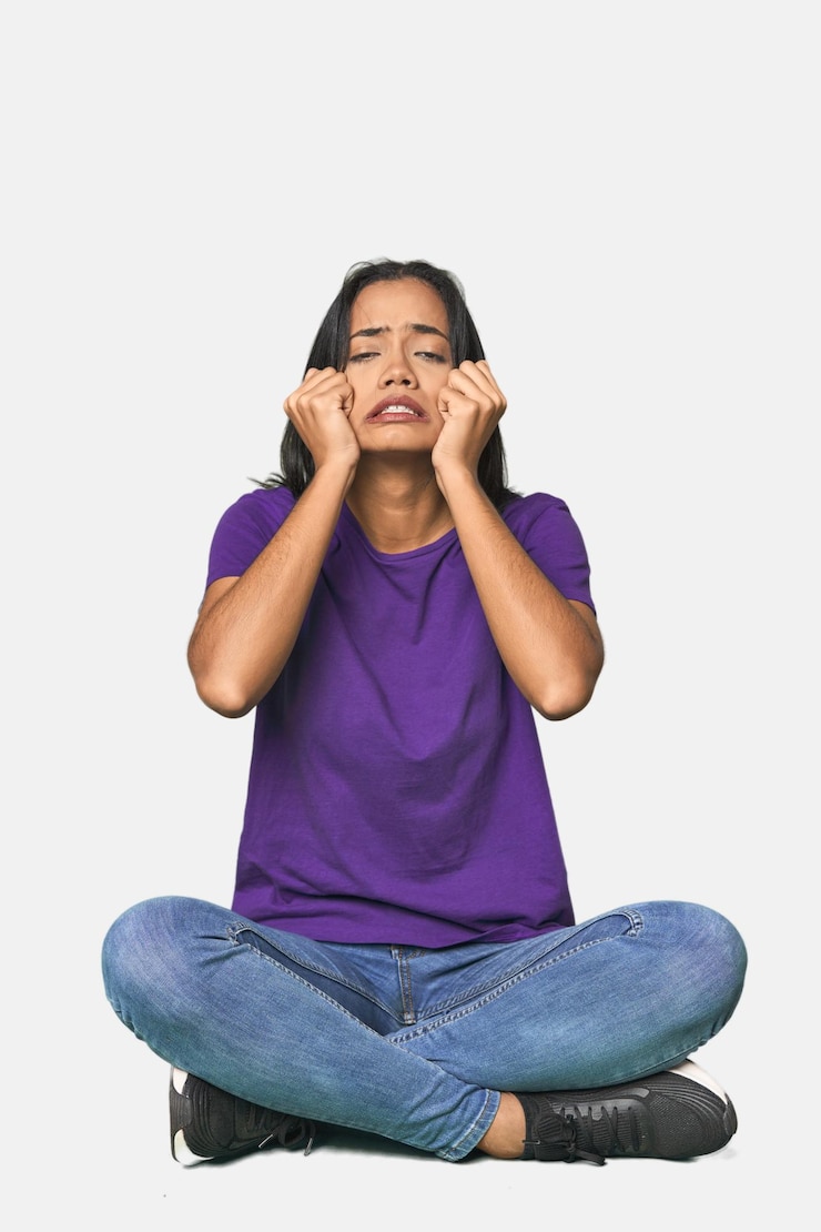 Foto latina sentada no chão no estúdio chorando infeliz com algo conceito de agonia e confusão