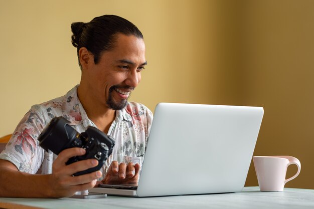 Latino Fotograf arbeitet zu Hause