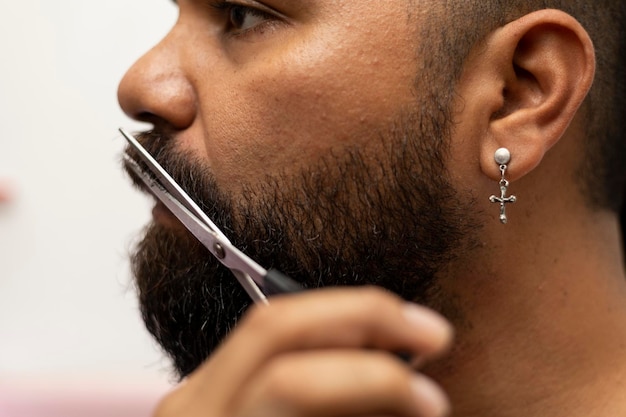 Latino-Mann 39 vor dem Spiegel benutzt eine Schere, um seinen Schnurrbart zu schneiden Closeup Barber Shop-Konzept