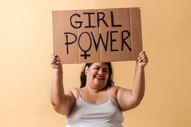 Latinx erwachsene Frau hält die Hände mit Girl Power Banner über
