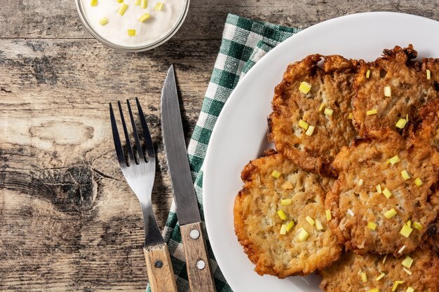 Latkes judíos tradicionales o tortitas de patata en mesa de madera