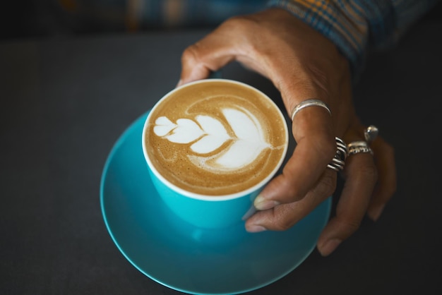 Latte art café y mano de barista con diseño de hojas cafeína y producto artístico con patrón en café Hombre creativo y dibujo con hospitalidad de espuma de leche con servicio y bebida de cerca