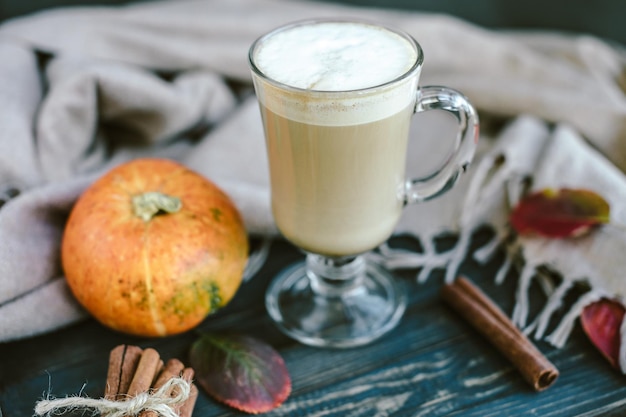 Latte de calabaza picante en una tabla de madera con un suéter